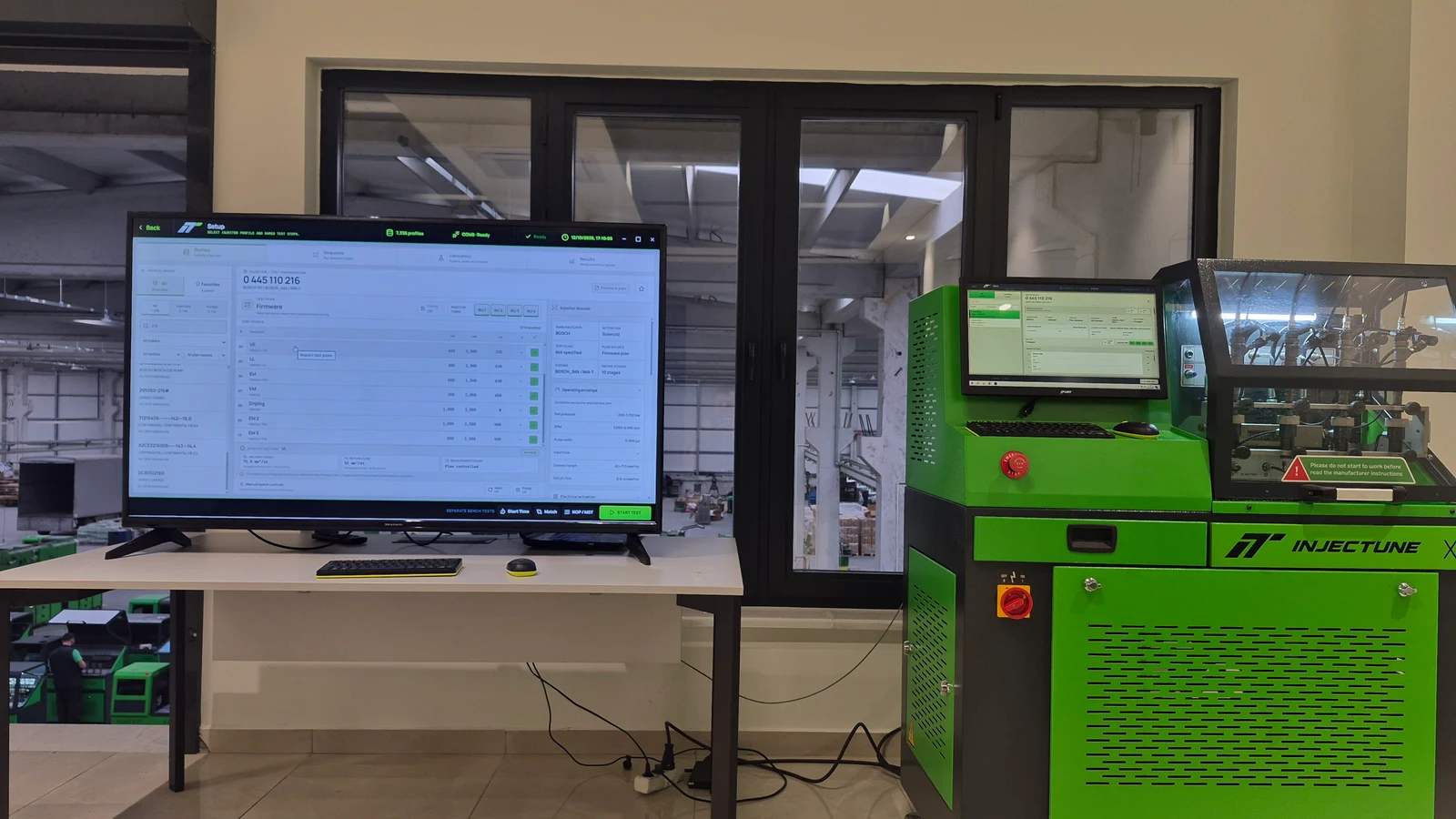 Injectune test bench beside a workstation displaying the injector test sequence.